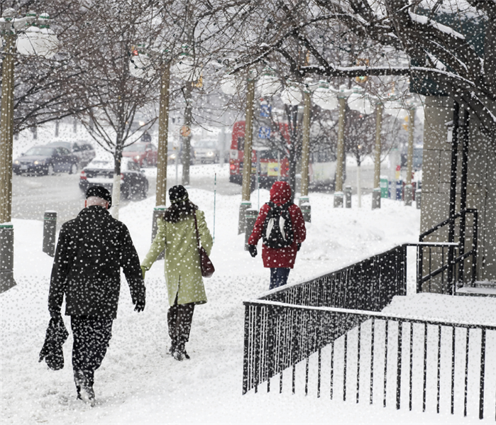 photo of people walking in blizzard on street